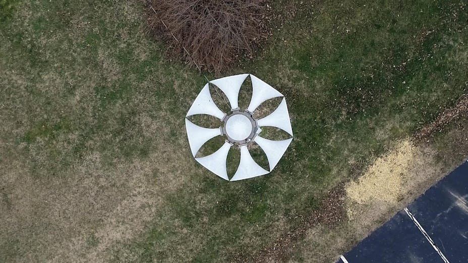 A large air raid siren on a large post.