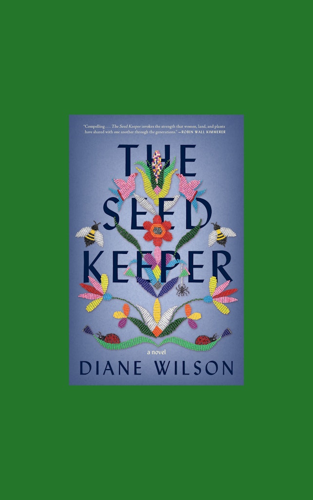 Three books on plants lie stacked on a wooden tabletop