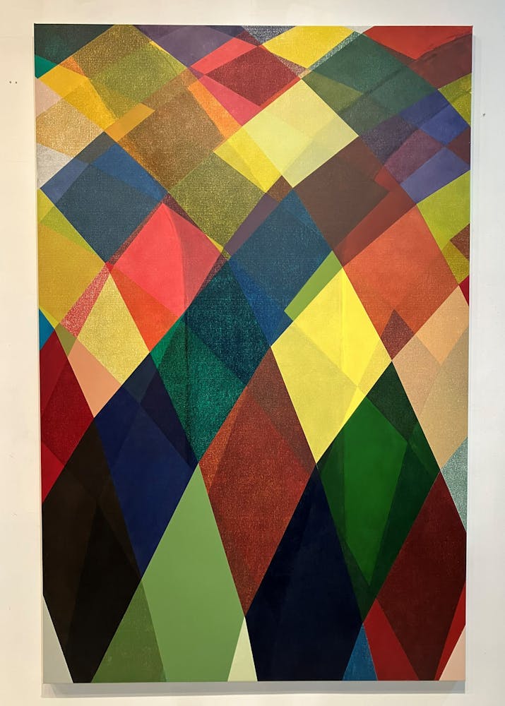 Abstract, colorful diamond shapes arc down from the top of a rectangular canvas.