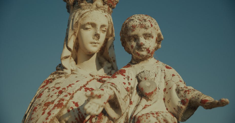 A statue of a woman wearing a crown holding a small child.