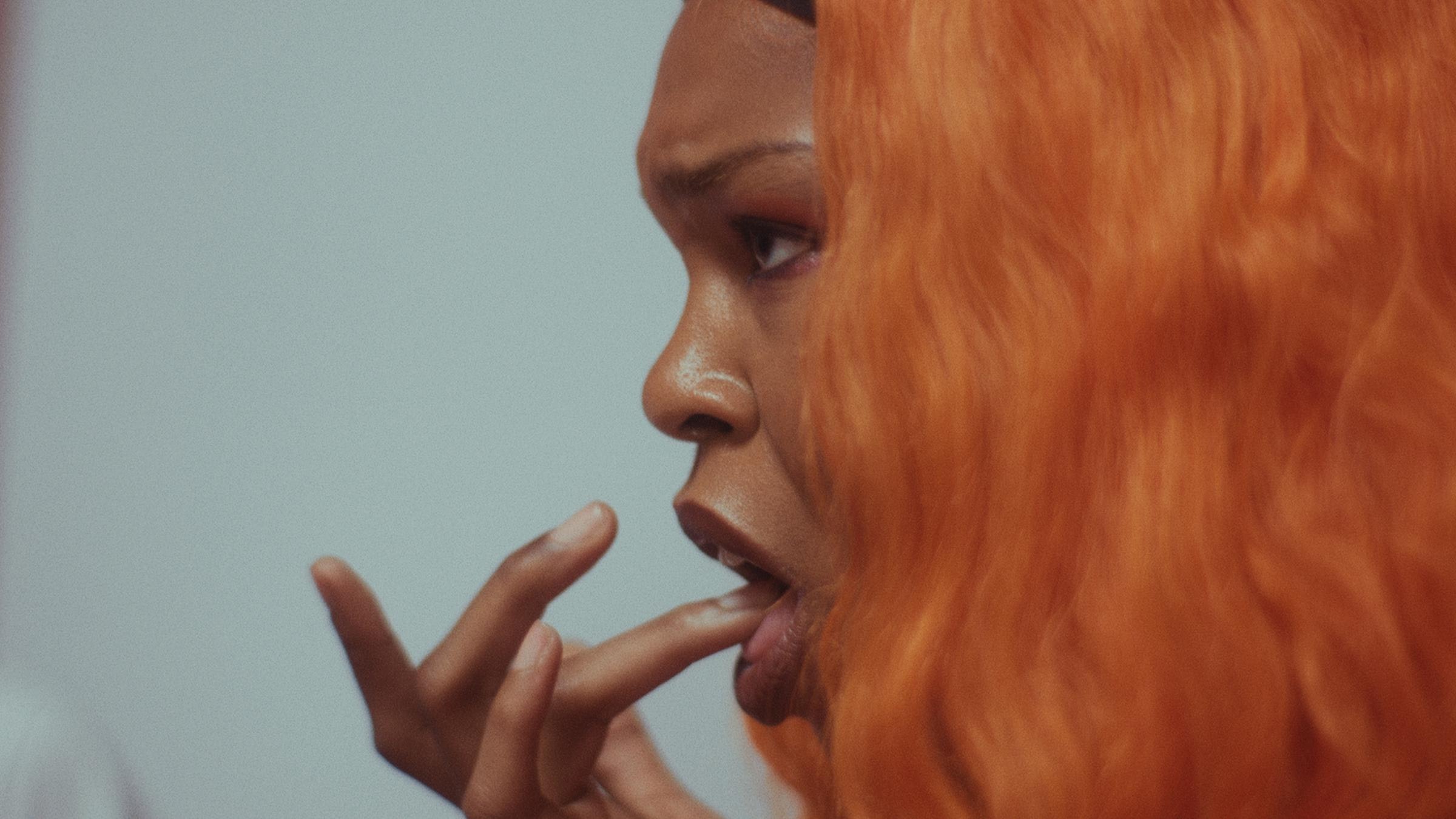 A women tastes the tip of her finger.