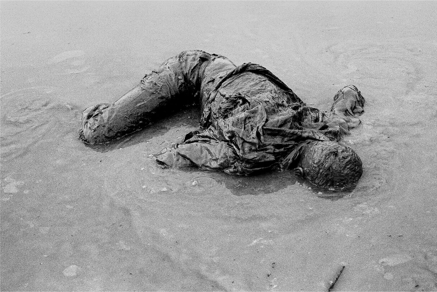 A man lies, face down in a pond.