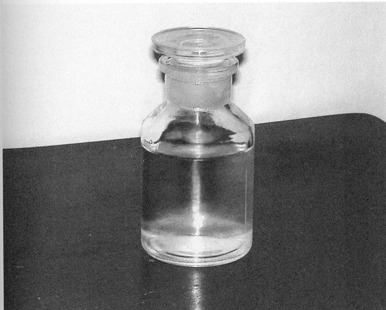 A small glass jar filled with water sits on a table.