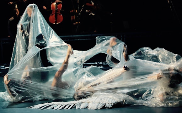 Dancers on the ground covered in plastic tarp.