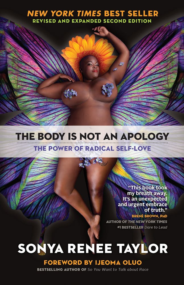 Photo of a nude full figured Black woman posing with fantastical butterfly wings and colorful colors over her breasts.