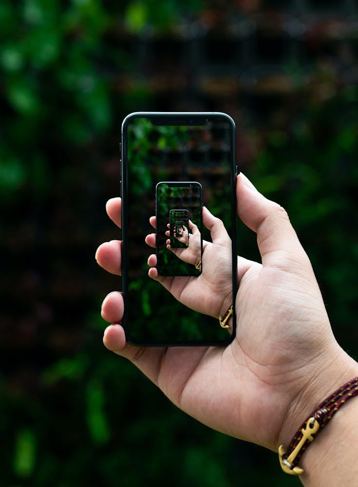 Image of hands using a an iPhone repeating into infinity on the iPhone screen