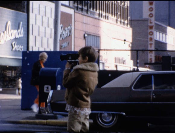 a young boy outside shooting film