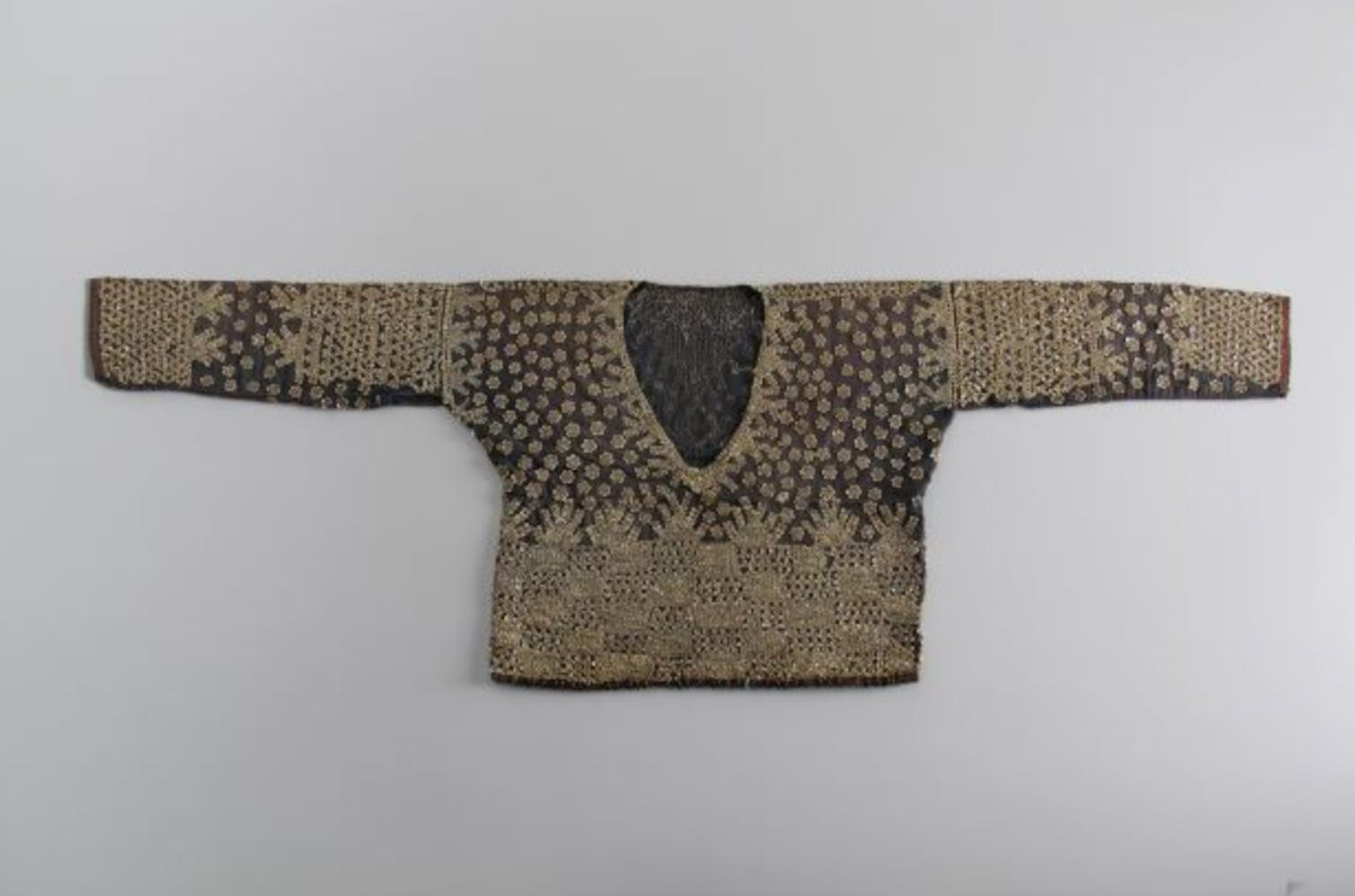 A women's long sleeve shirt like tunic with geometric patterns woven into it.