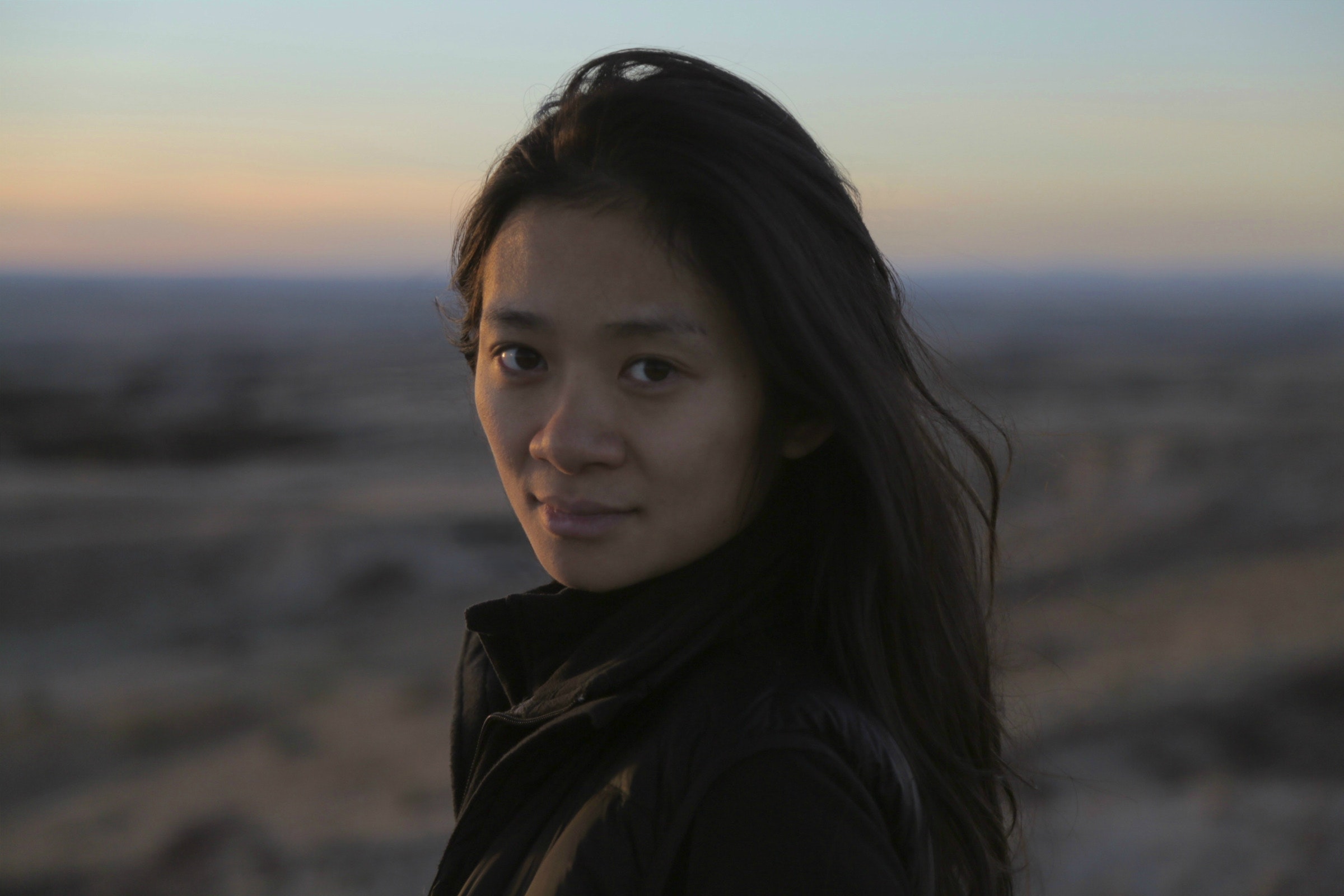 Portrait of filmmaker Chloé Zhao in front of a sunset