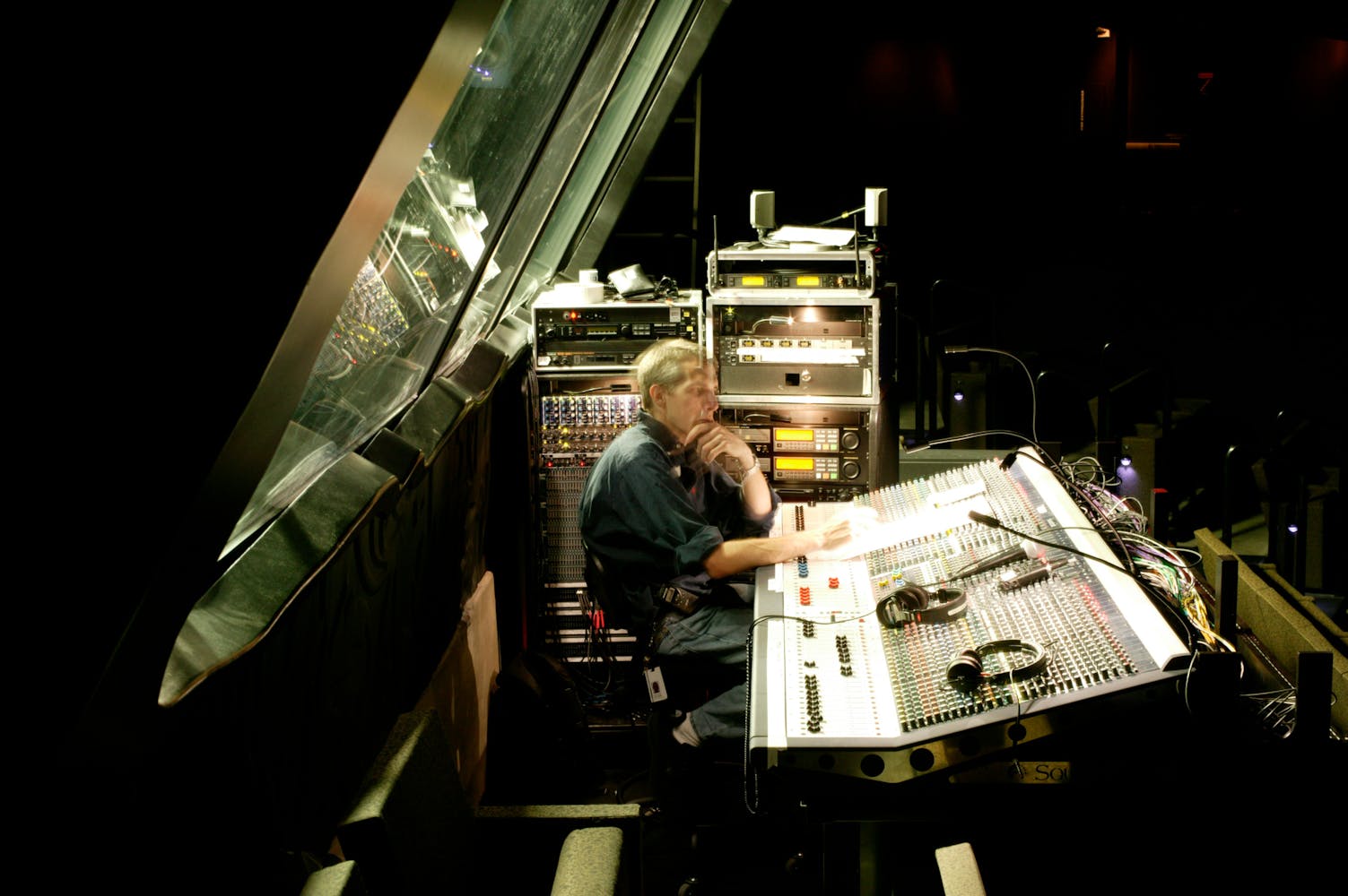 A sound tech adjusts levels at a control panel.