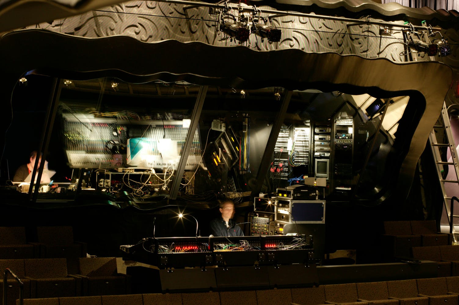 Technicans work in a theater tech booth.