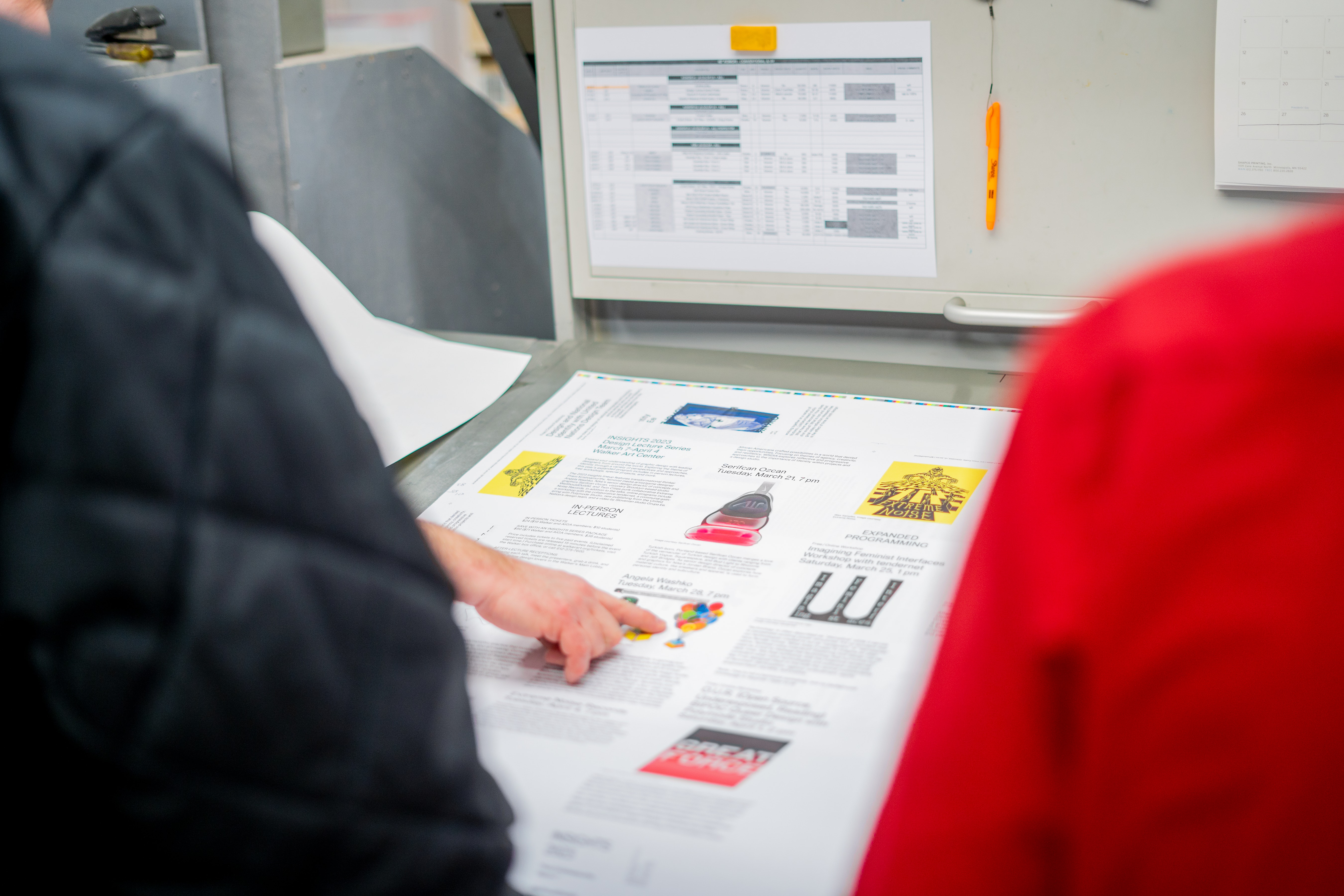 A hand pointing to a graph of some kind on a table