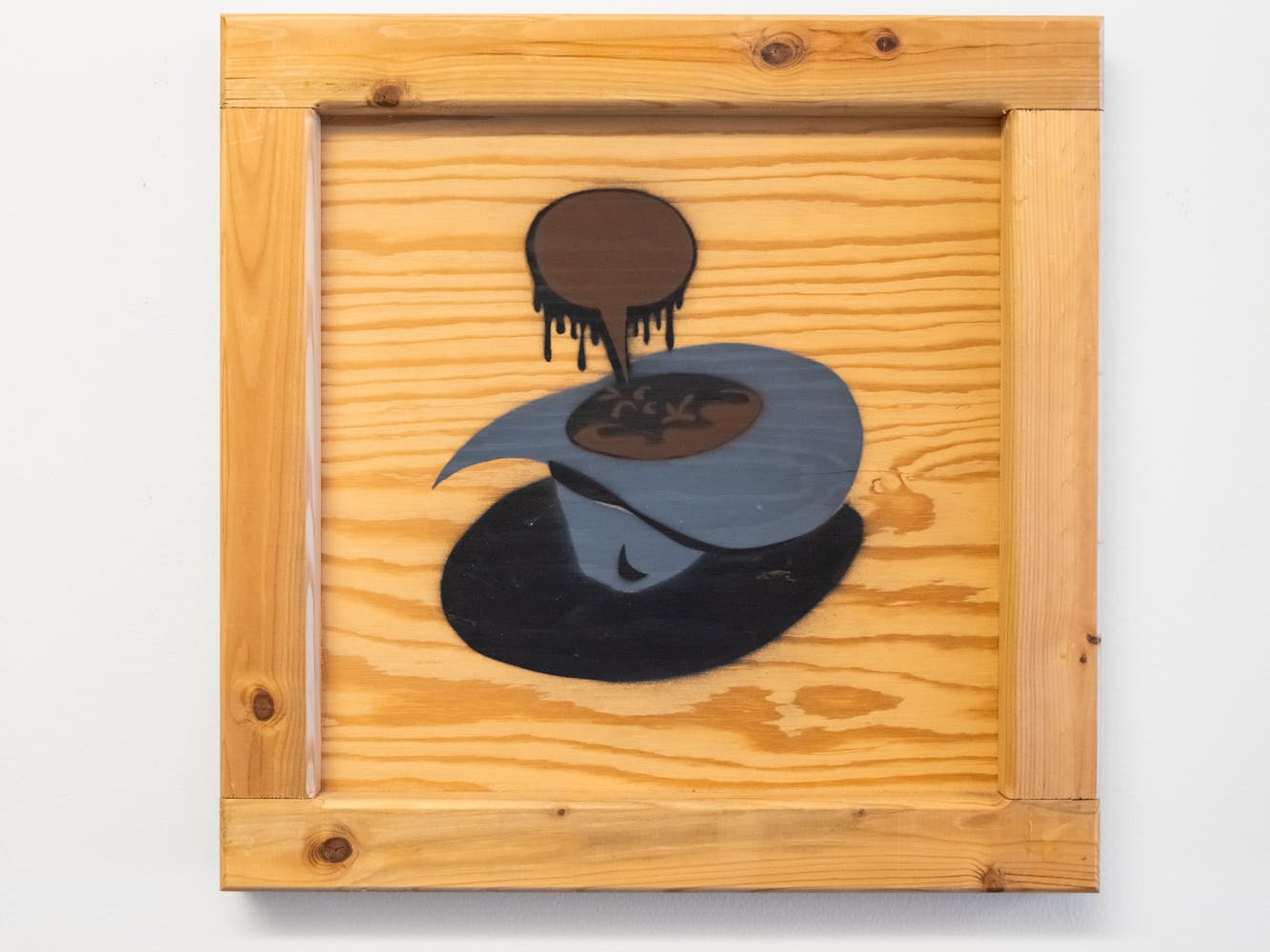 A wood square peice of art with an illustration iof a cowboy hat in the center