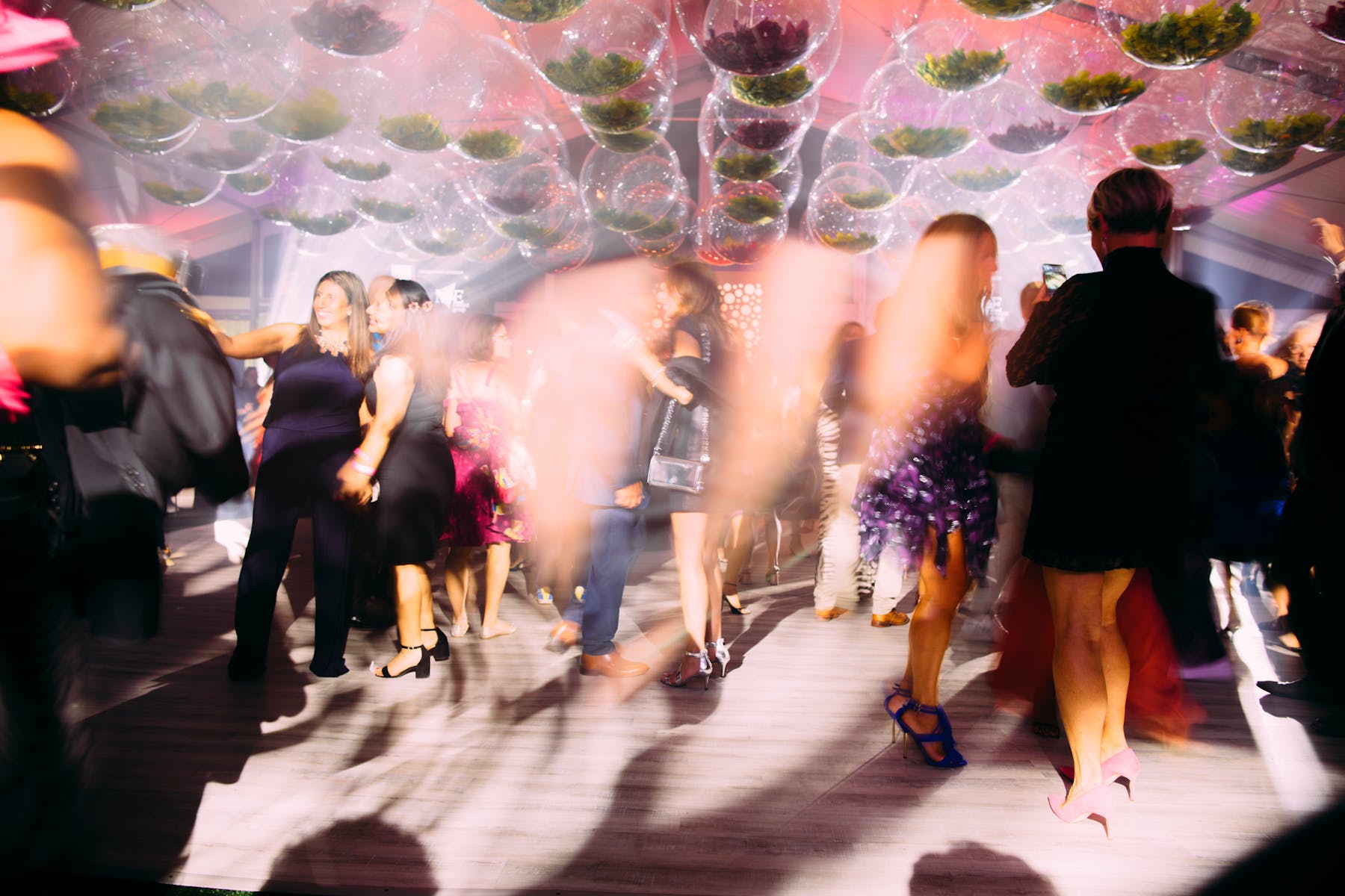 Blurry image of people dancing under translucent globes