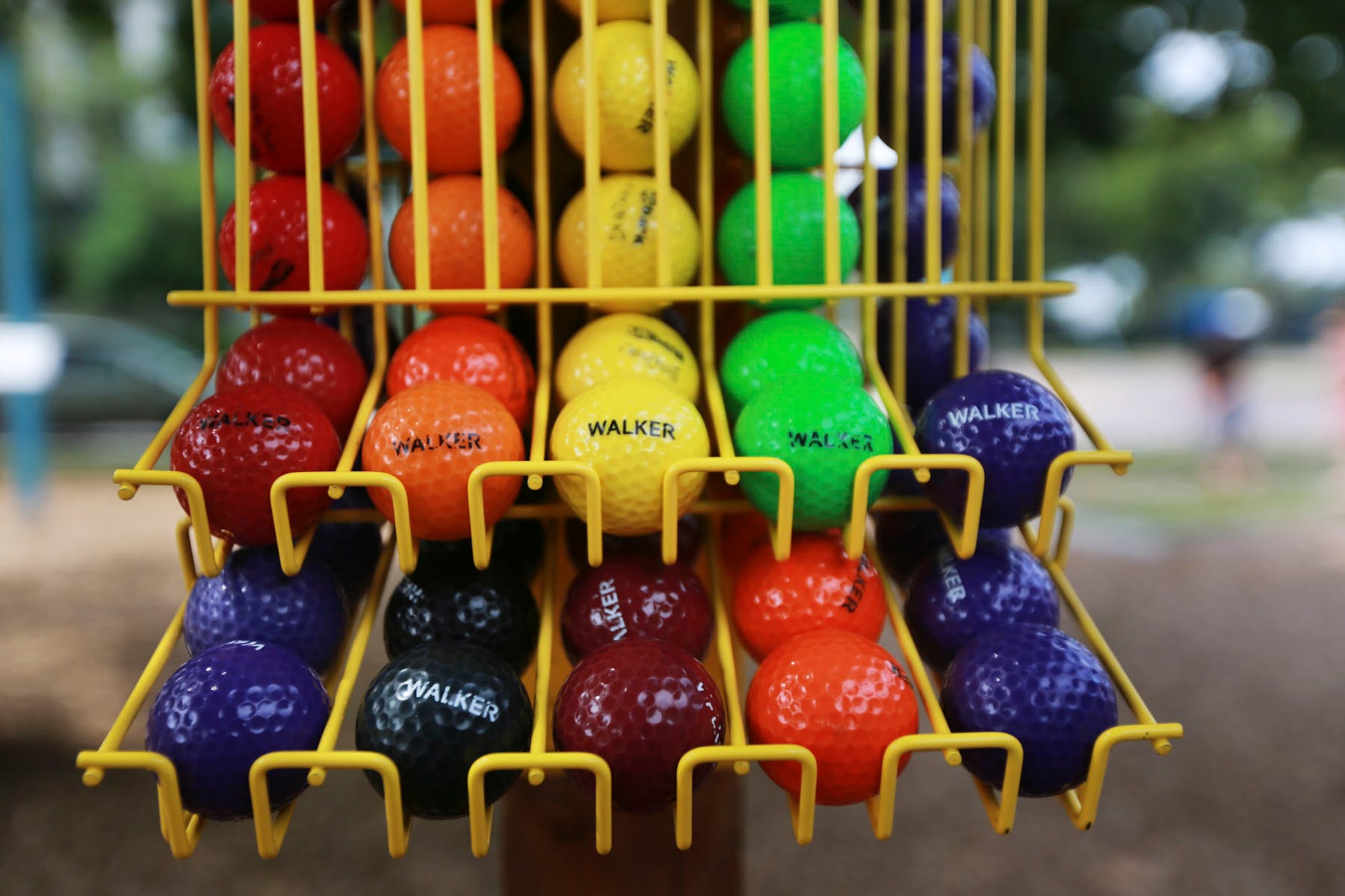 multi-colored golf balls in ball rack.
