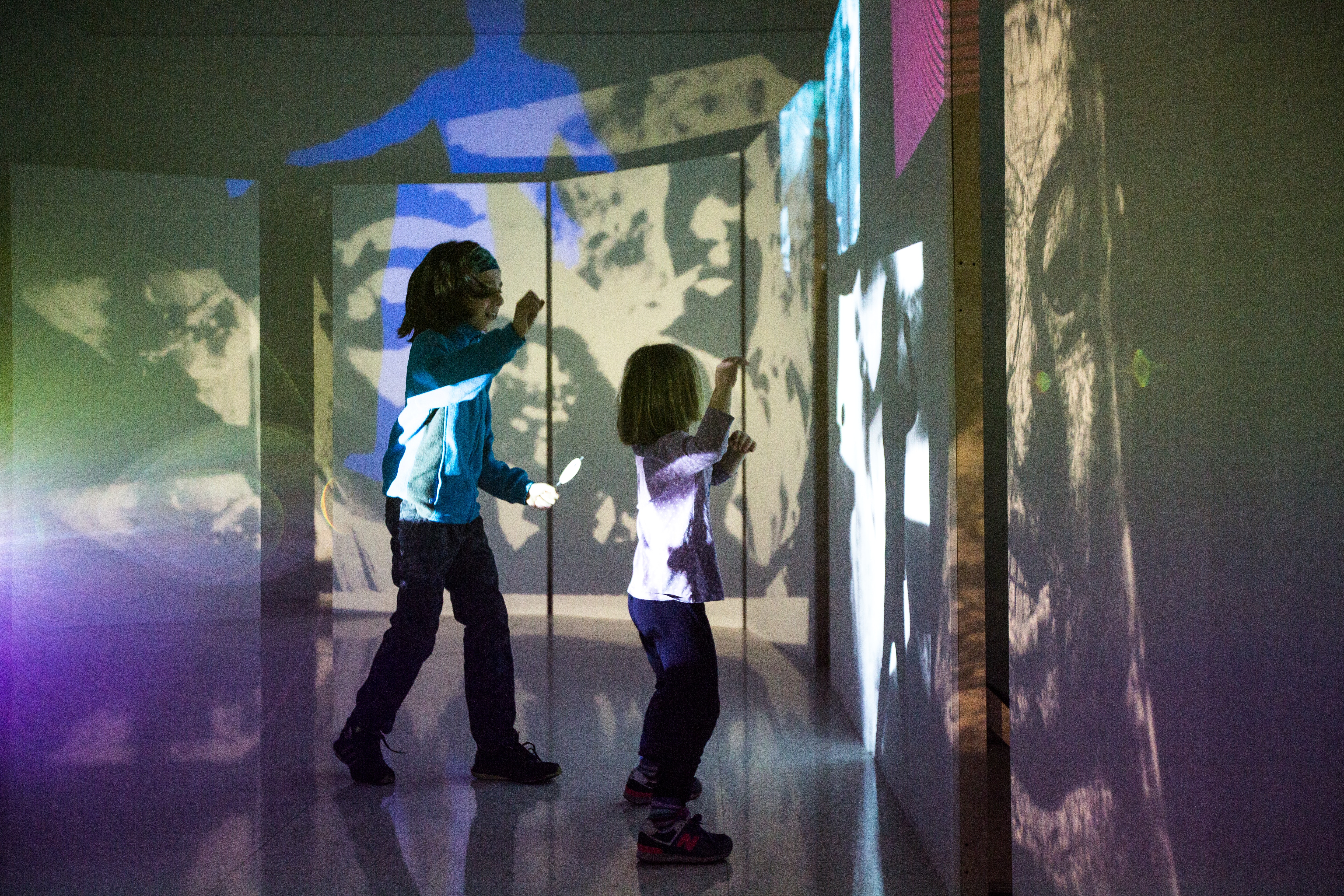 Illustration of a child with blue hair and a yellow shirt in a dark space with a few cartoon trees around.