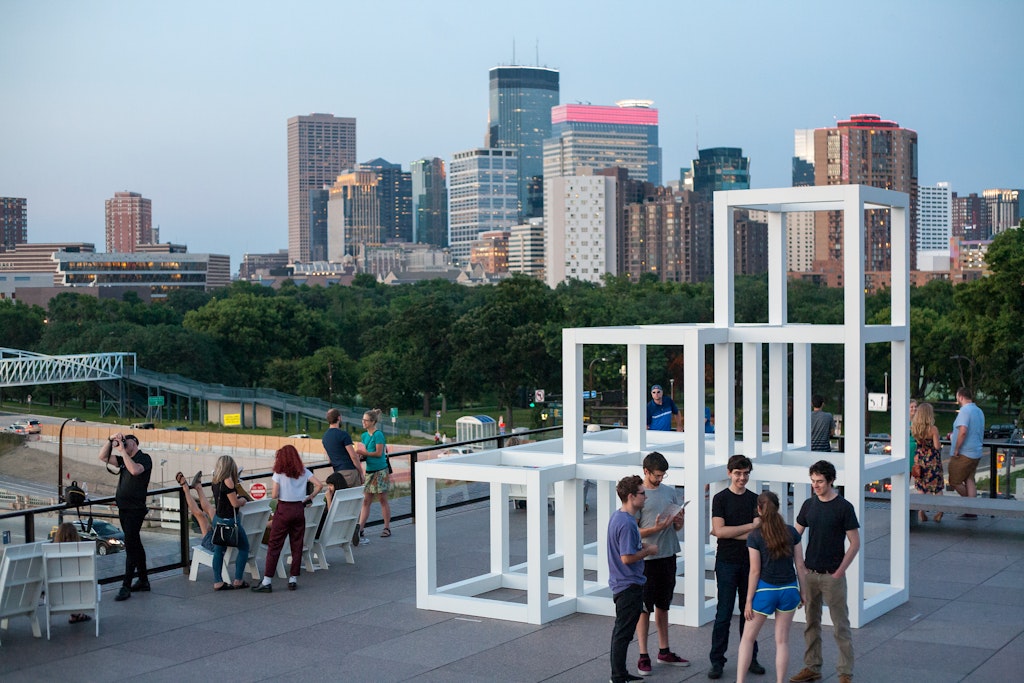 People on the terraces, city skyline views, view of the Irene Whitney Hixon bridge by Armajani, terrace seating and tables.