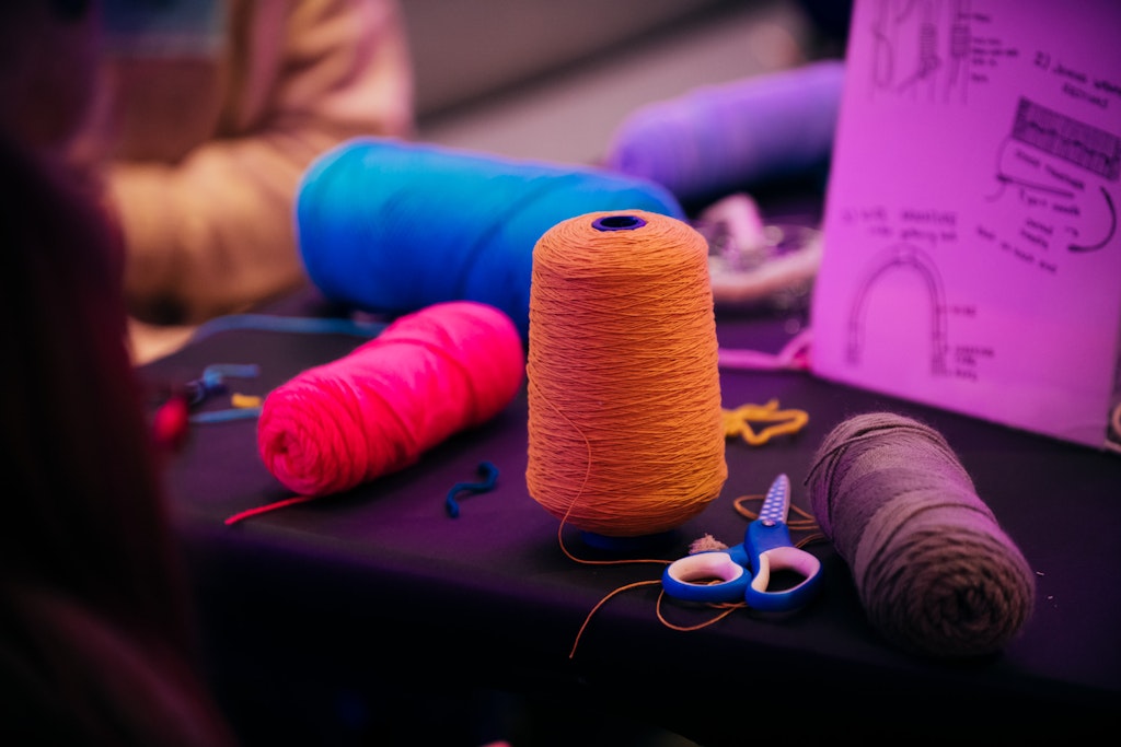 Colorful spools of thread and scissors on a table.