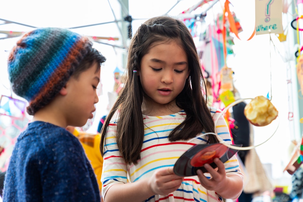 Two children looking at a colorful art installation.