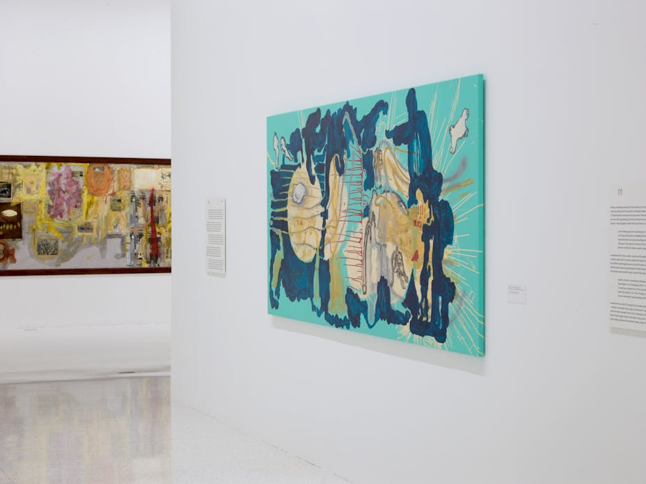 Image of abstract artworks hung on walls in gallery space with white walls.