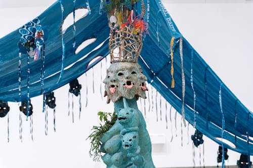 Blue fabric tent with multicolored sculpture underneath