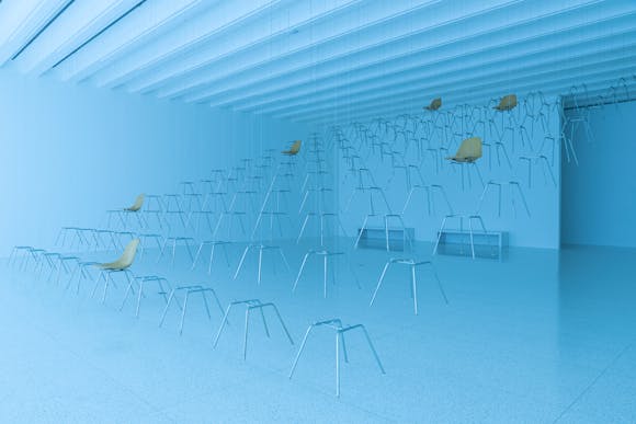 Gallery bathed in blue light with chairs and chair legs suspended from the ceiling
