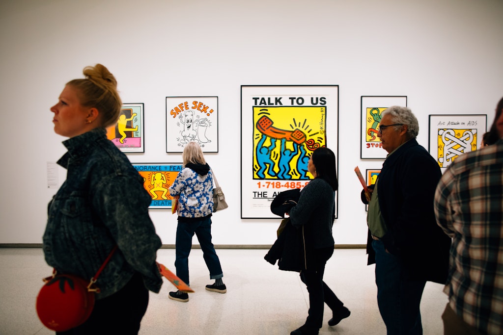 People walking in action in the Keith Haring exhibit.
