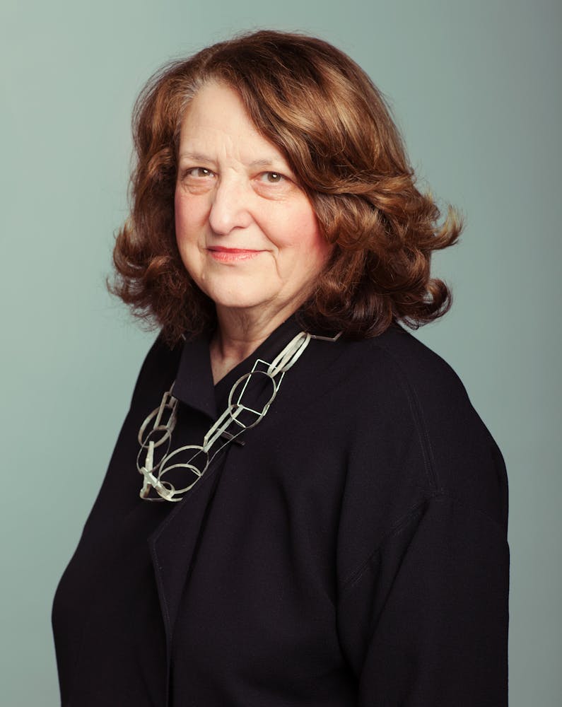 A woman looks at the viewer and smiles.