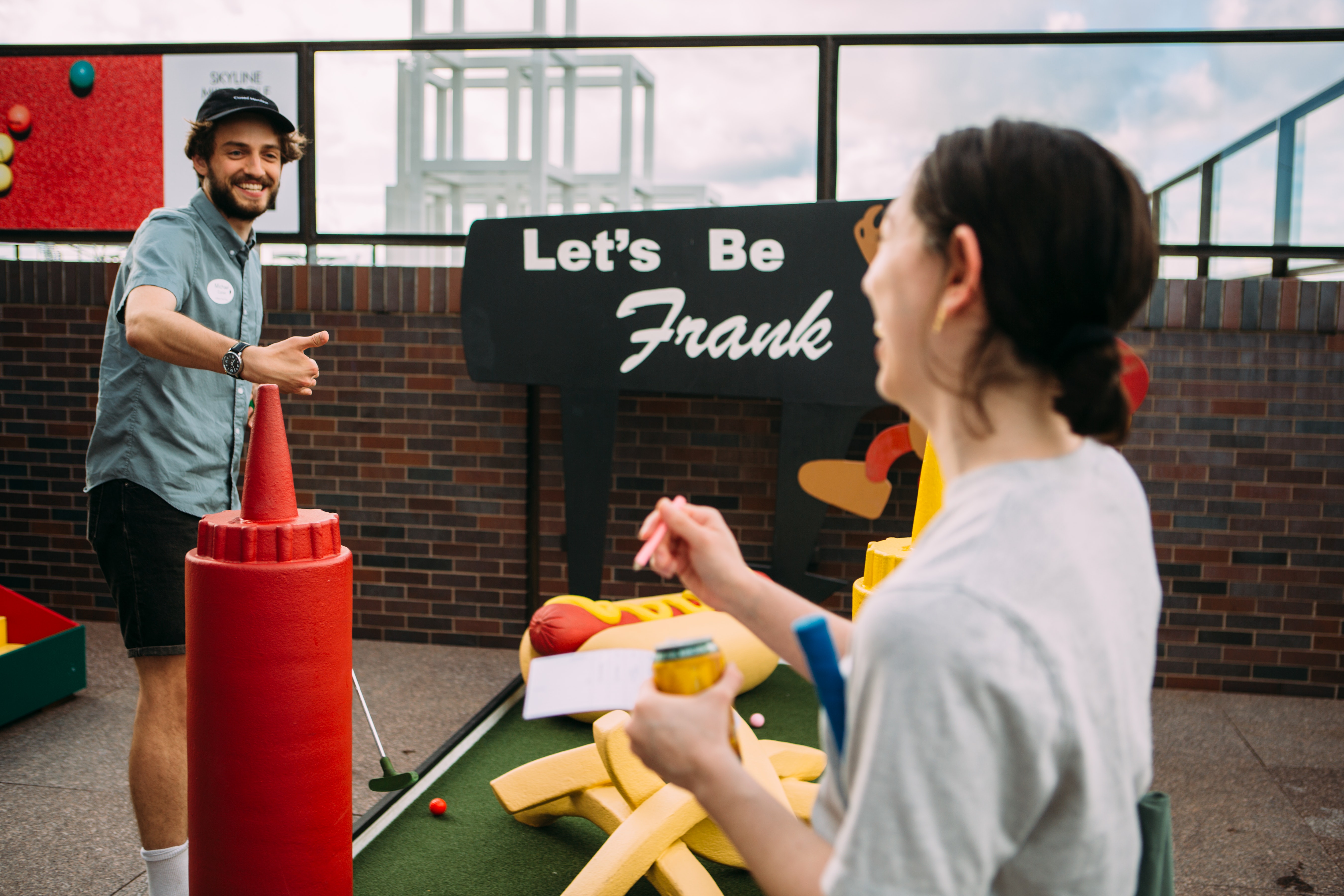 Two adults face with other, one gives a thumbs up. A 