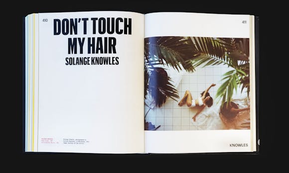 Open book spread with large text saying "Don't Touch My Hair" and image of woman on ground on the right
