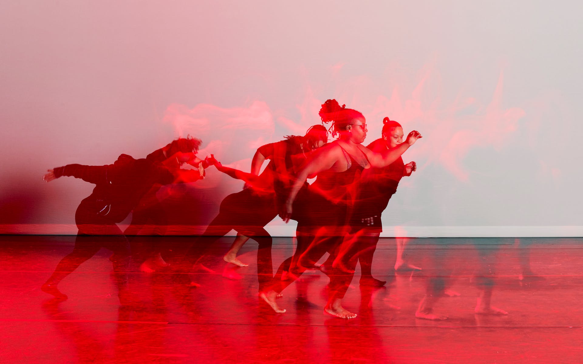 Black and red image of dancers on stage.