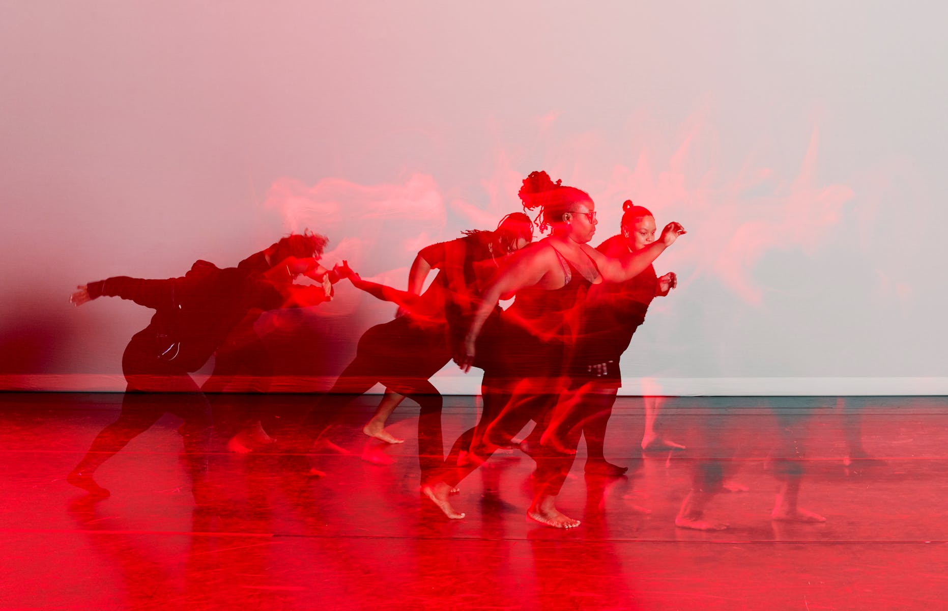 Black and red image of dancers on stage.