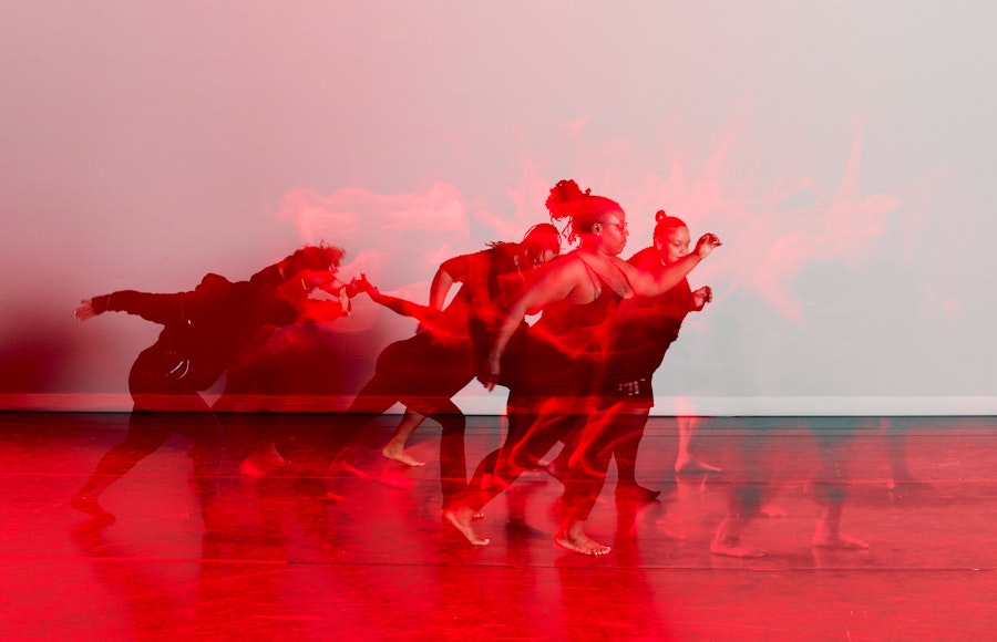 Black and red image of dancers on stage.