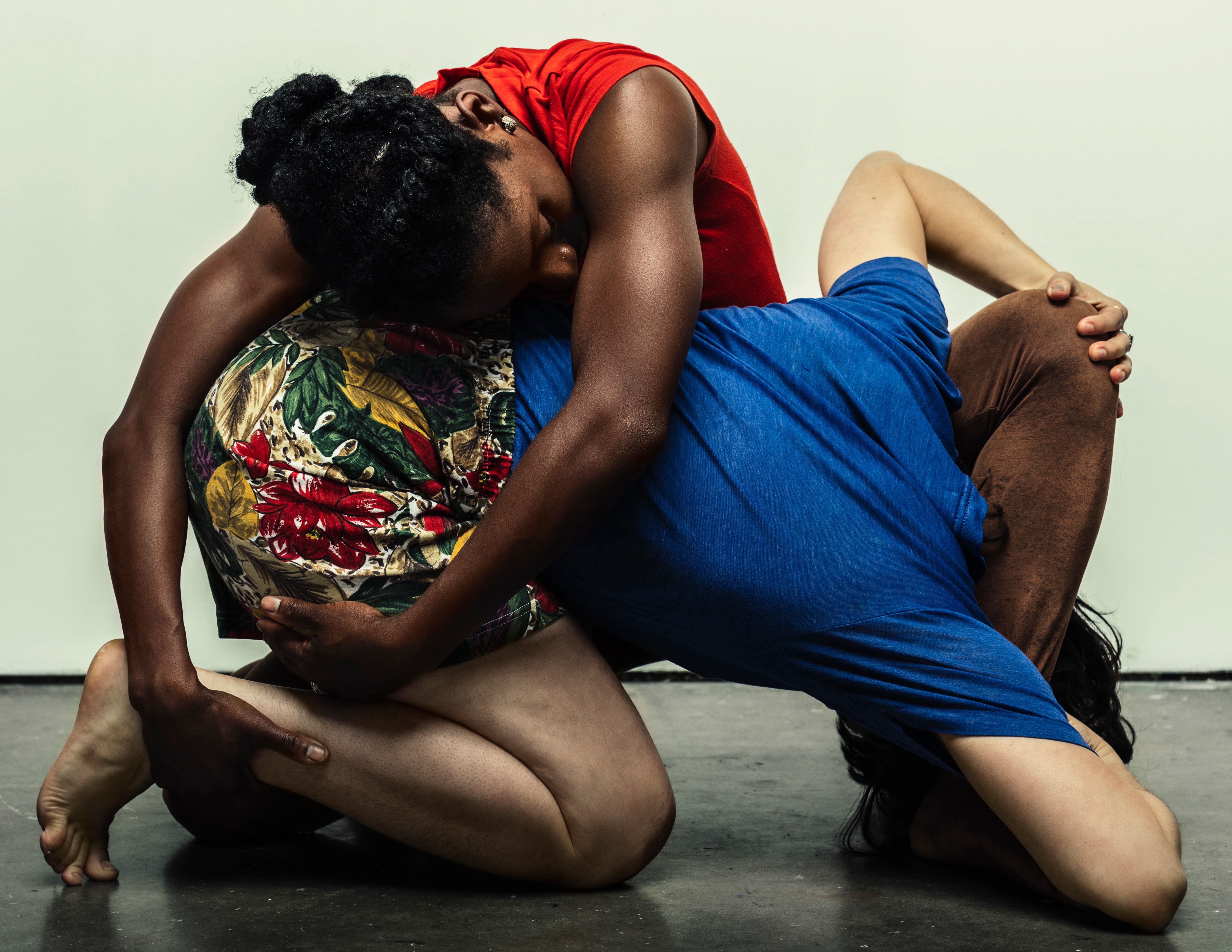 Two performers embrace on the ground in a hard to understand jumble of limbs.