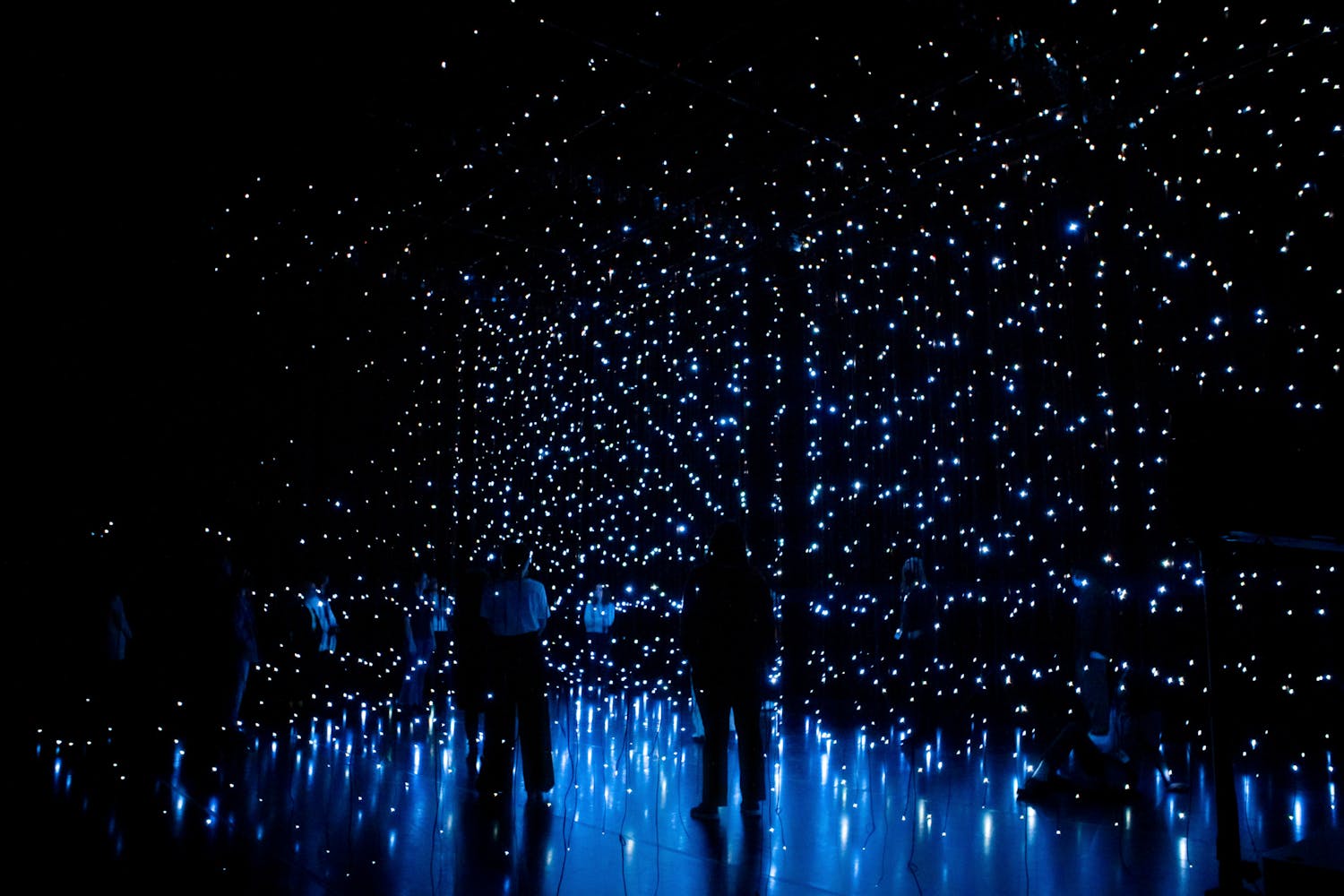 Dark figures stand in grids of stars.