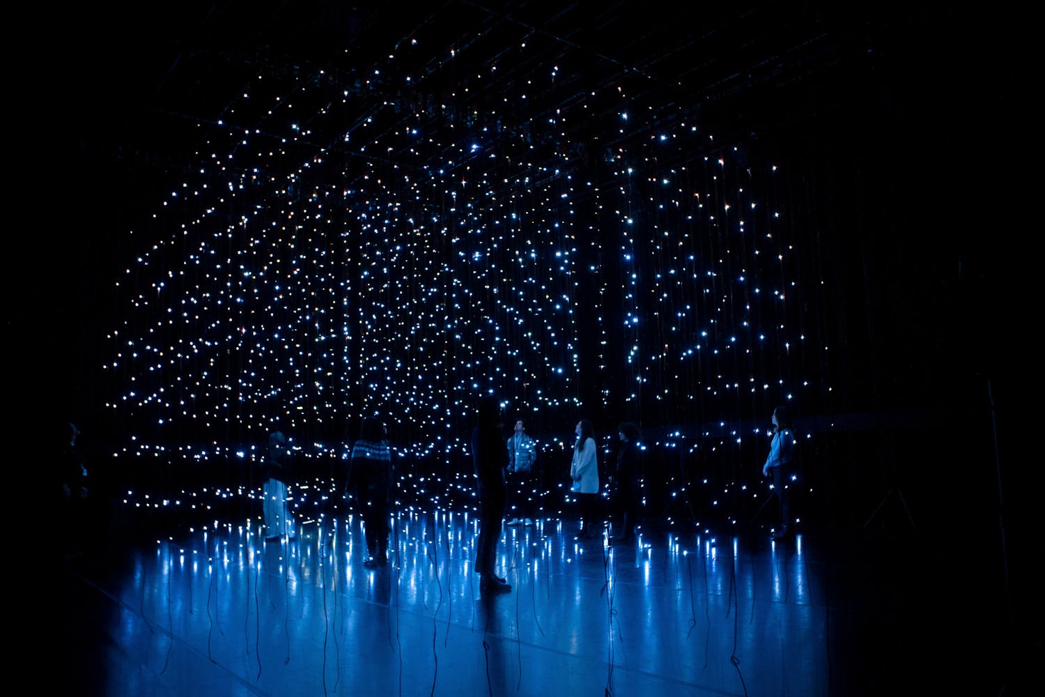 Dark figures stand in grids of stars.