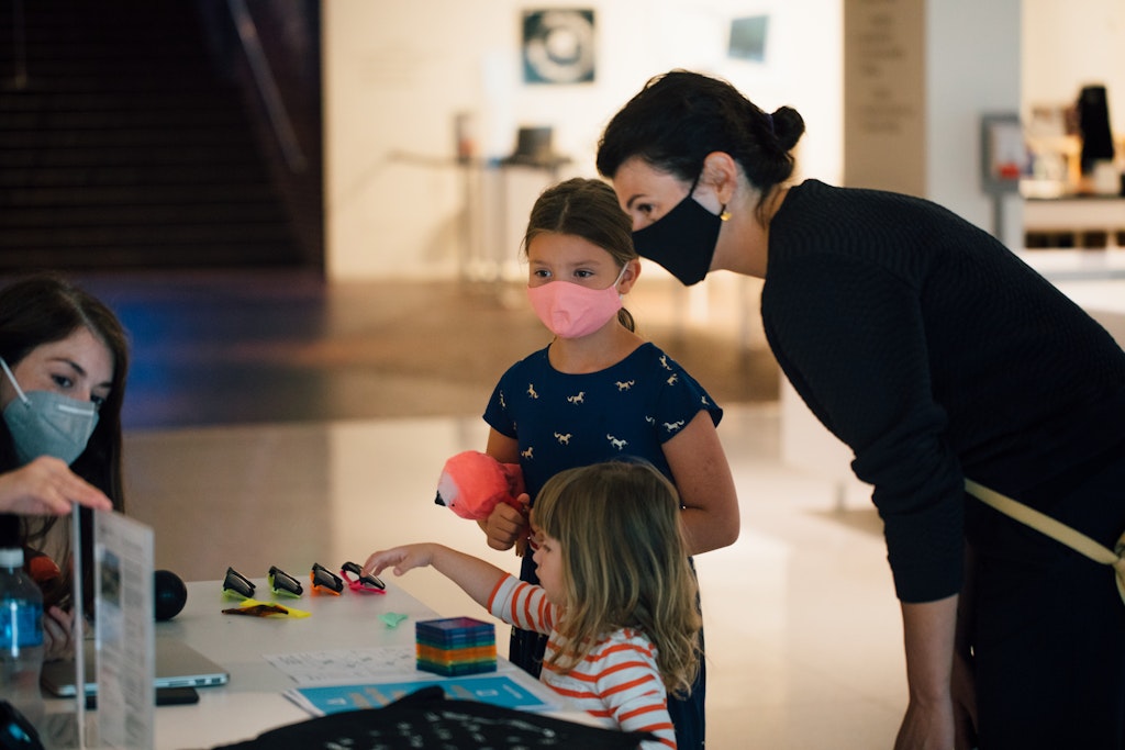 Two adults and two children looking at sunglasses and fidgets