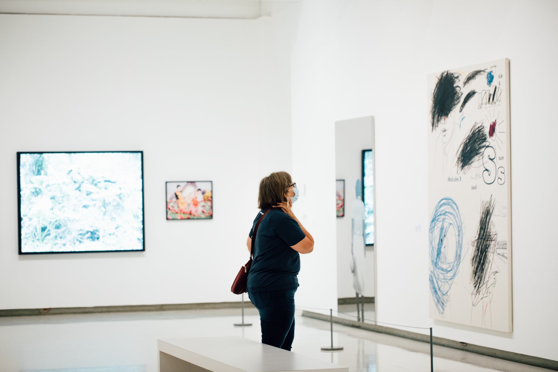 Adult looking at artwork in a gallery.