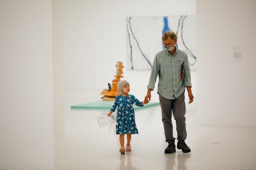 Child and adult walking in a gallery
