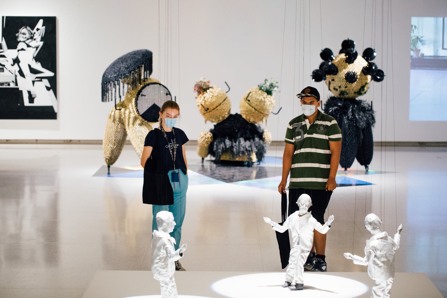 Two adults looking at a marionette sculpture.