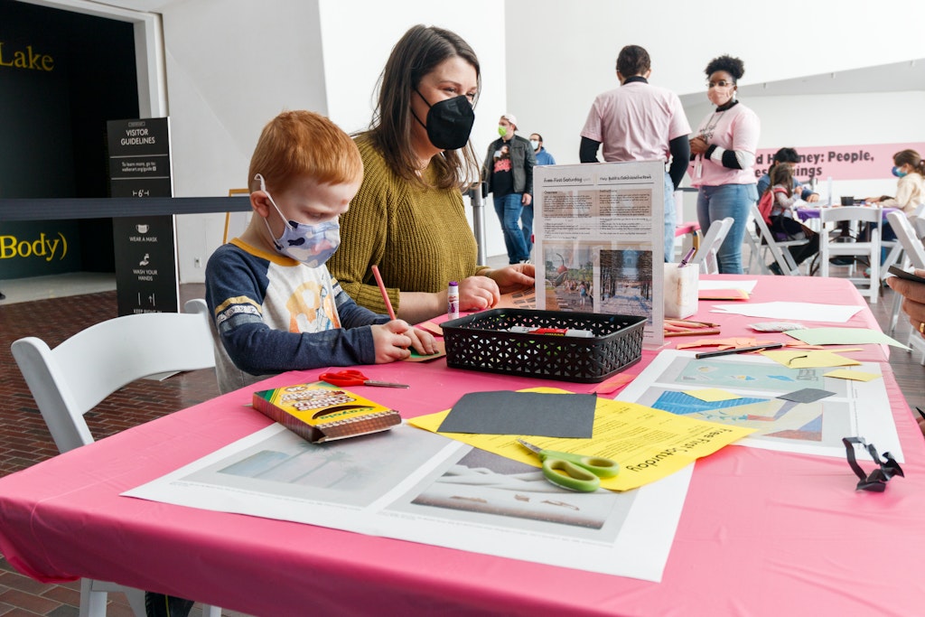 Child and adult seated at a table making art