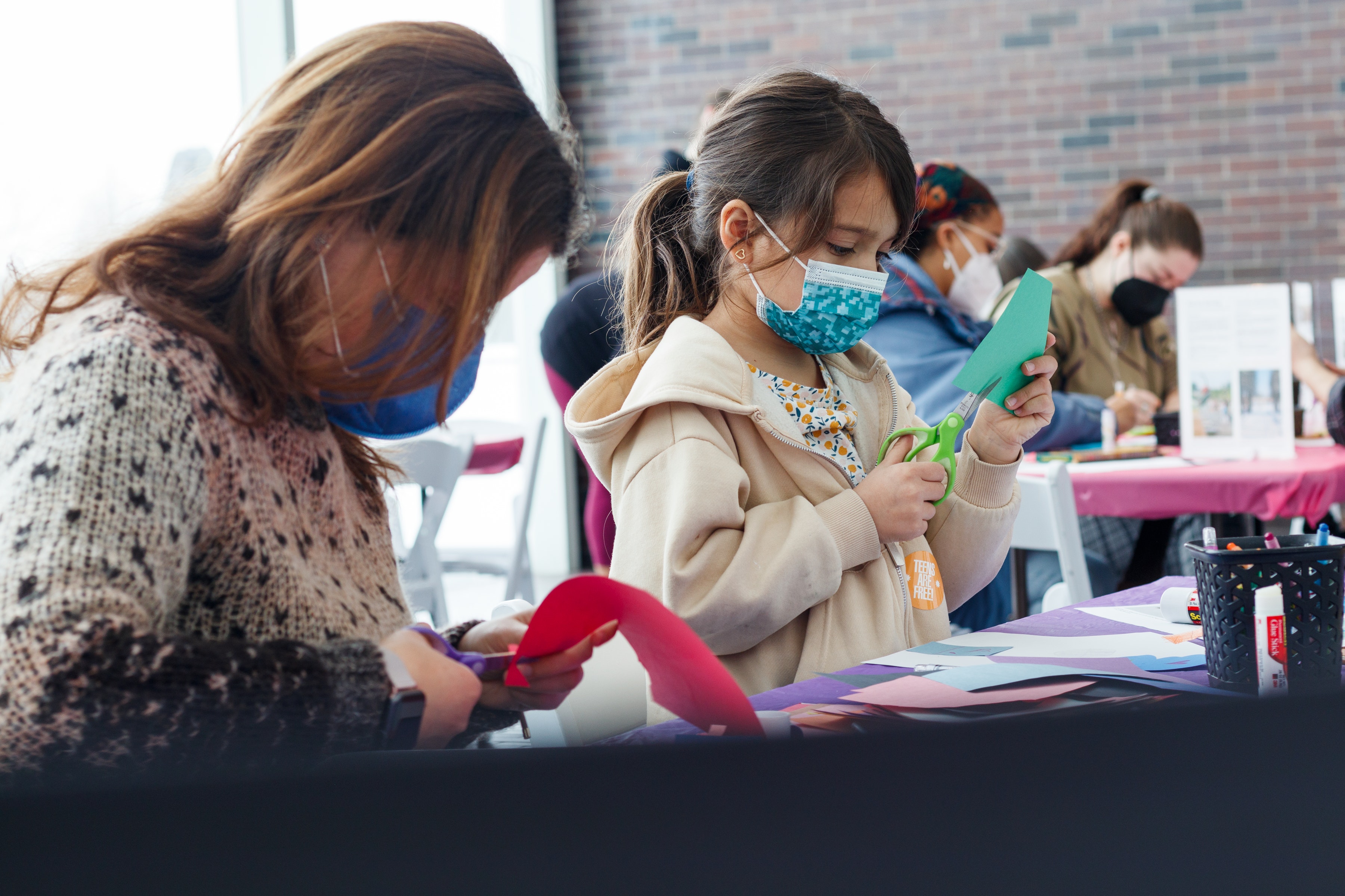 Adult and child using scissors to make art