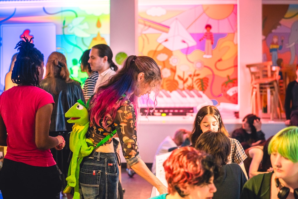 Teens sit together making art and stand around chatting in the Walker’s Art Lab.