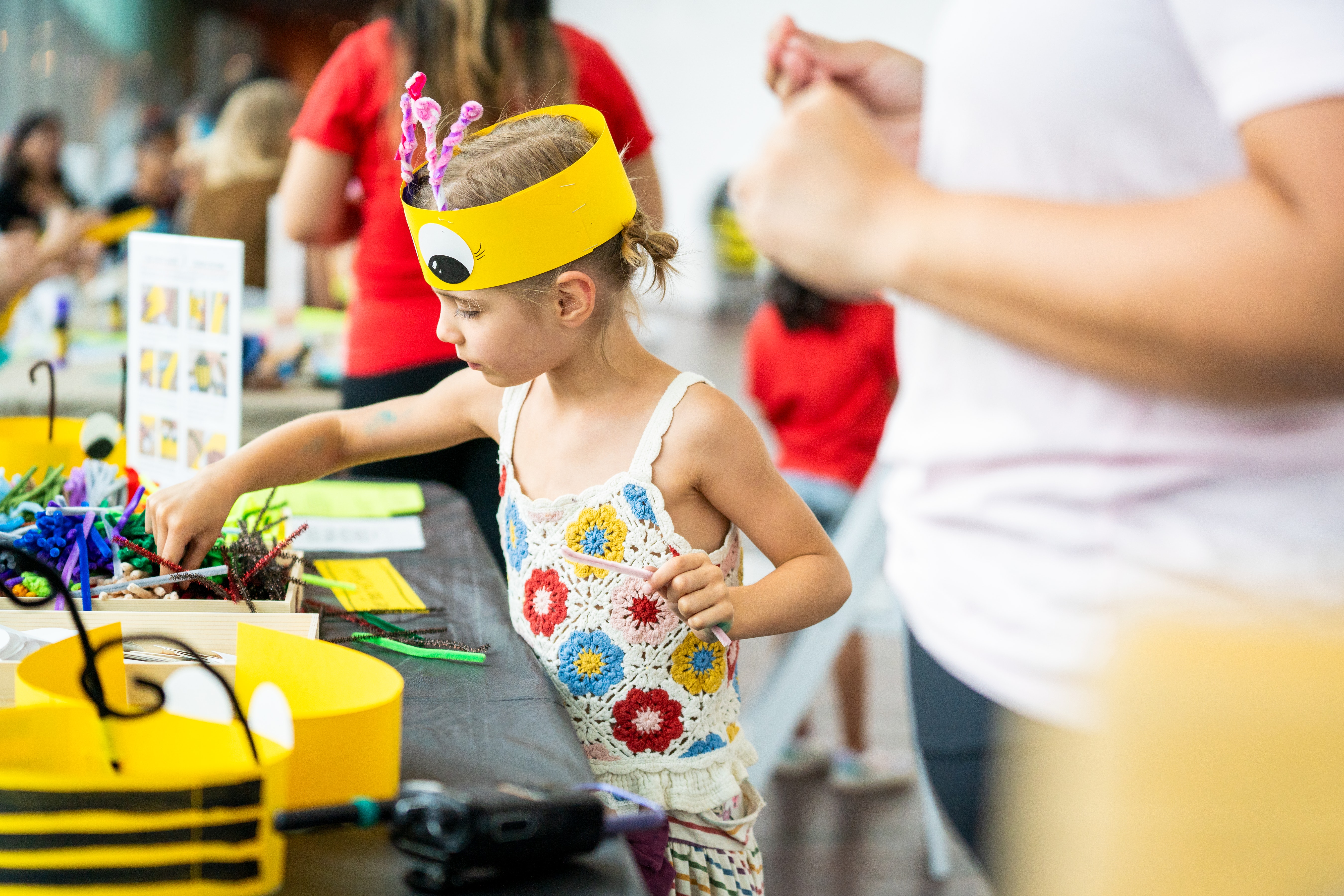 Illustration of a child with blue hair and a yellow shirt in a dark space with a few cartoon trees around.