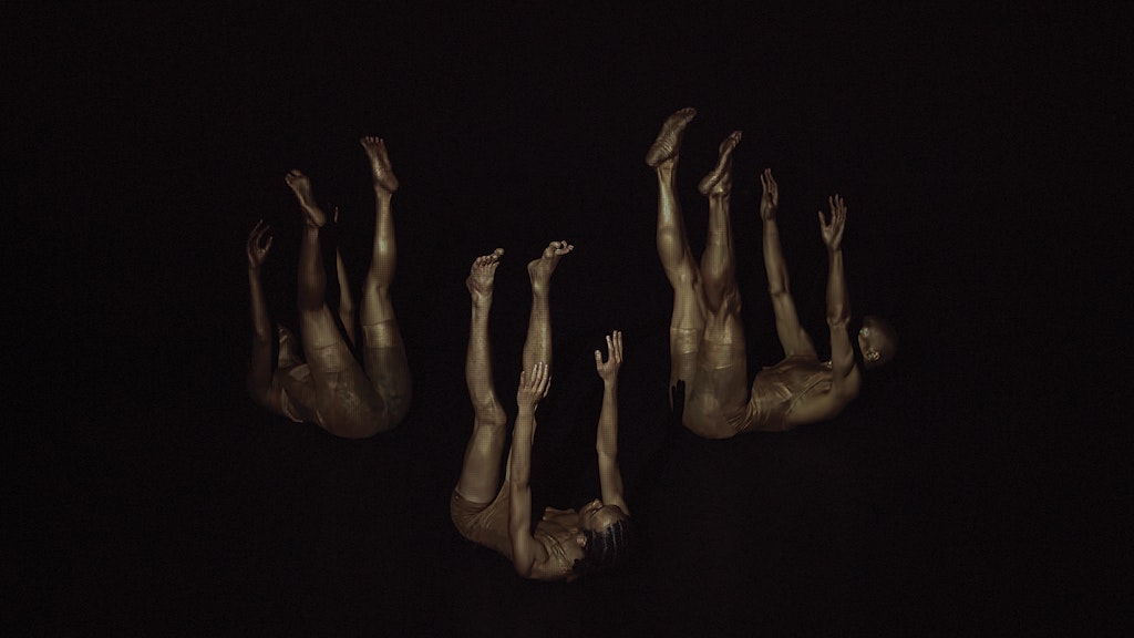 Against an all-black background, a monochromatic image of three dancers with dark skin who each appear to be falling from the sky, with their arms and legs raised upward.
