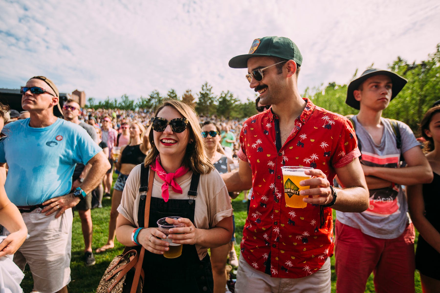 A couple enjoys glasses of Summit beer surrounded by the crowds of an outdoor concert at the Walker Art Center.