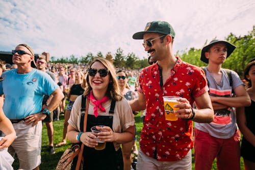 A couple enjoys glasses of Summit beer surrounded by the crowds of an outdoor concert at the Walker Art Center.