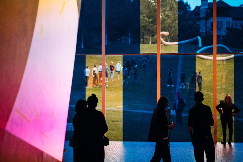 Several people in a space with colorful shapes on top of the photograph.