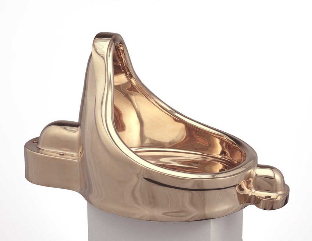 A sculpture of a golden urinal.