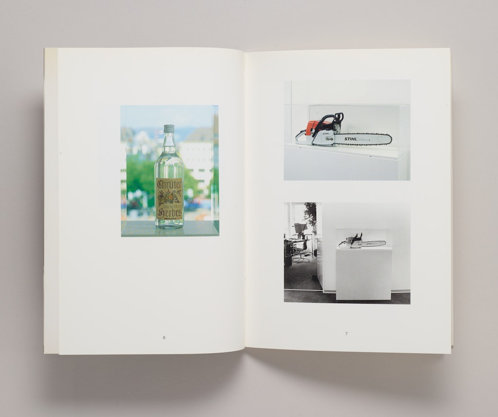 An open book with photographs of chainsaws and a glass bottle.
